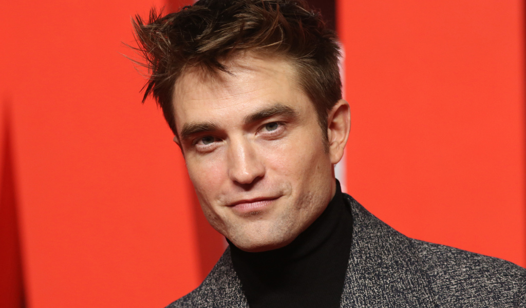 Актер Роберт Паттинсон на красном фоне