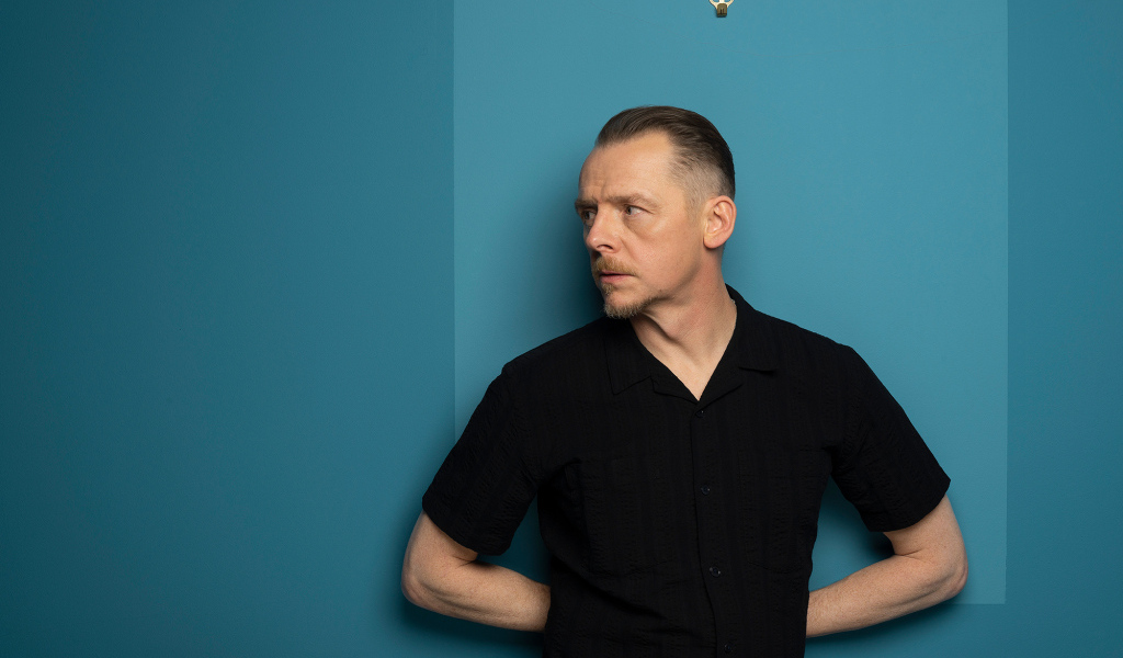 Актер Саймон Пегг  стоит у стены