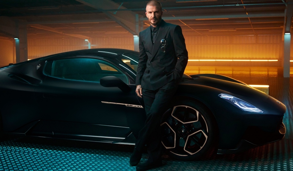Футболист Дэвид Бекхэм у черного автомобиля Maserati MC20