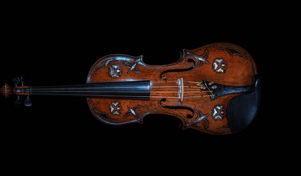 Большая деревянная скрипка на черном фоне