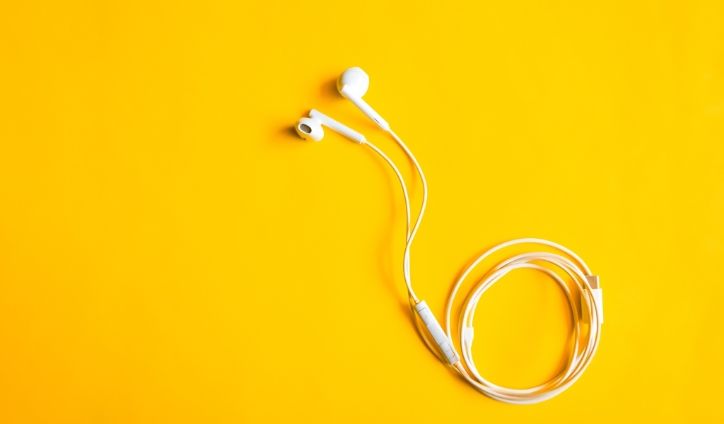 Белые наушники на желтом фоне