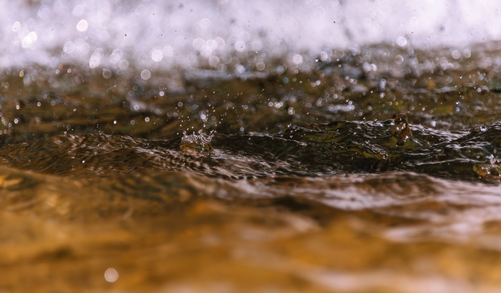 Сильные капли дождя падают в воду