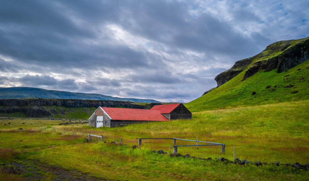 Дом у покрытой зеленью поры под грозовым небом