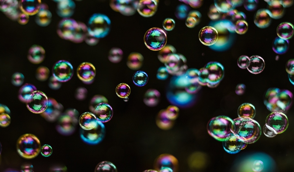 Разноцветные мыльные пузыри на черном фоне