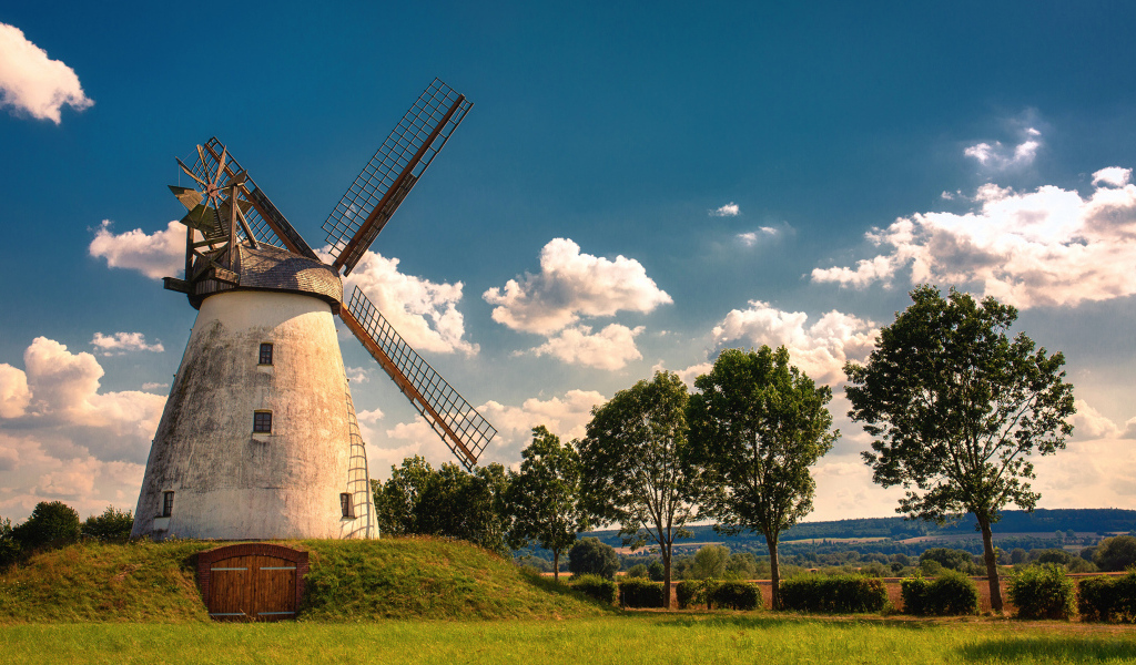 Старая мельница с зелеными деревьями