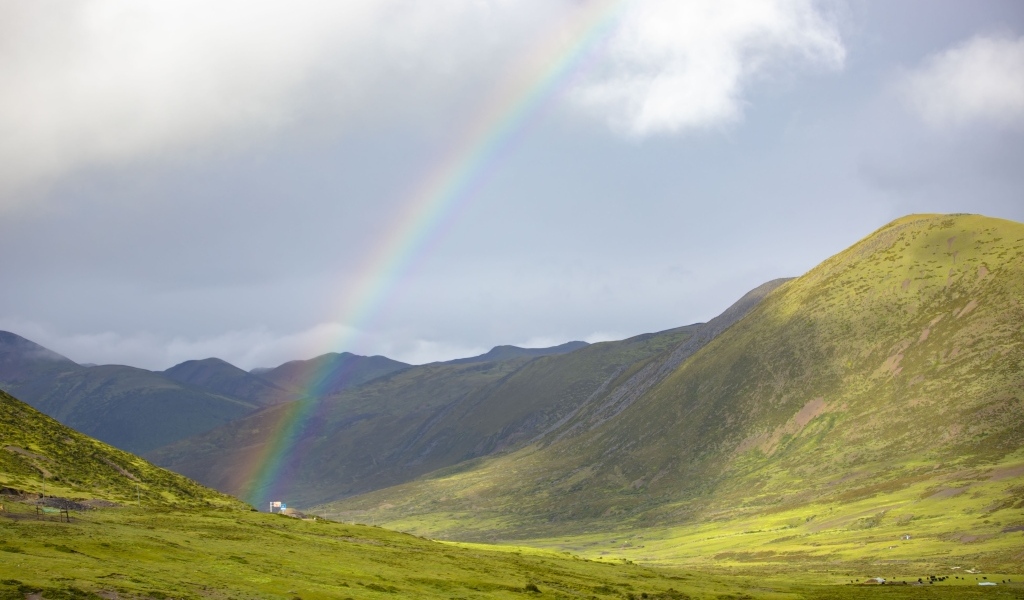 Радуга над покрытыми зеленью холмами