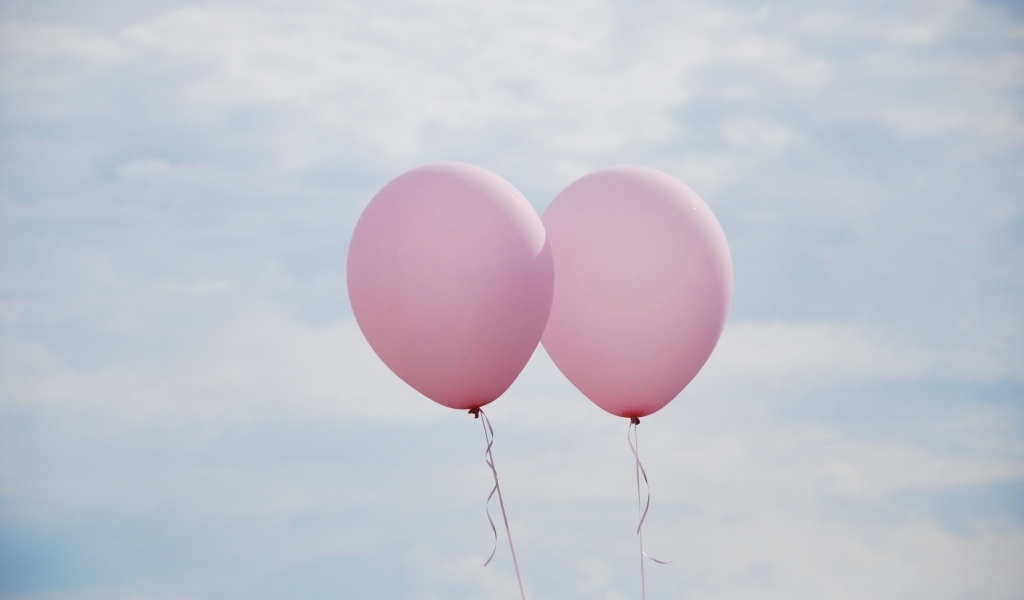 Два розовых воздушных шарика в небе