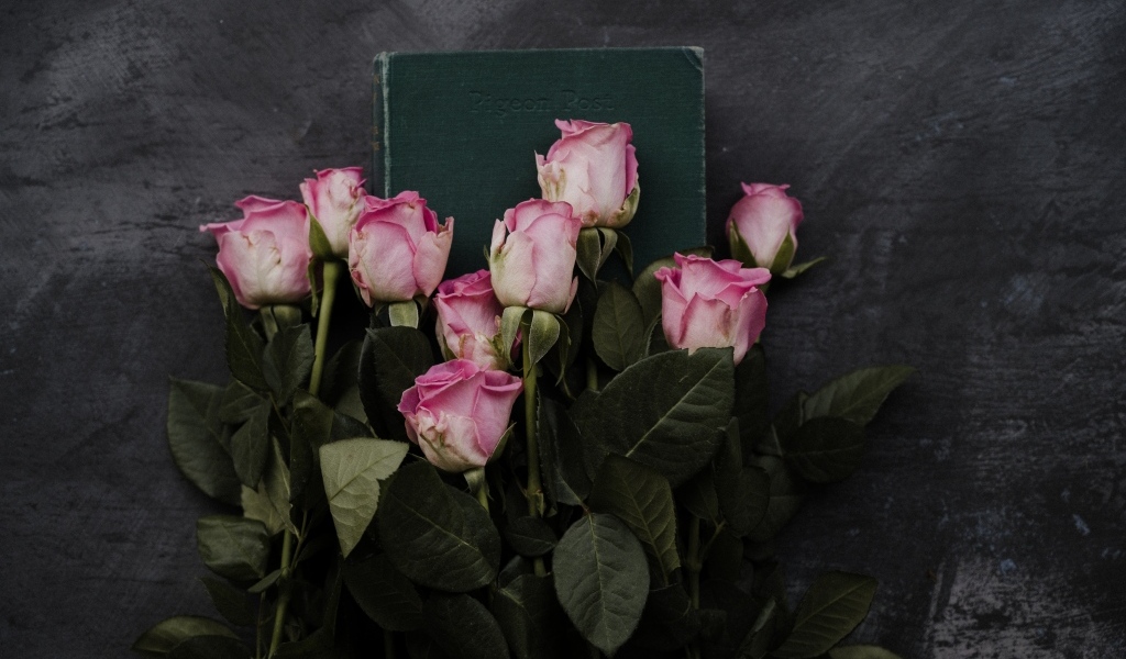 Букет розовых роз с книгой на сером столе