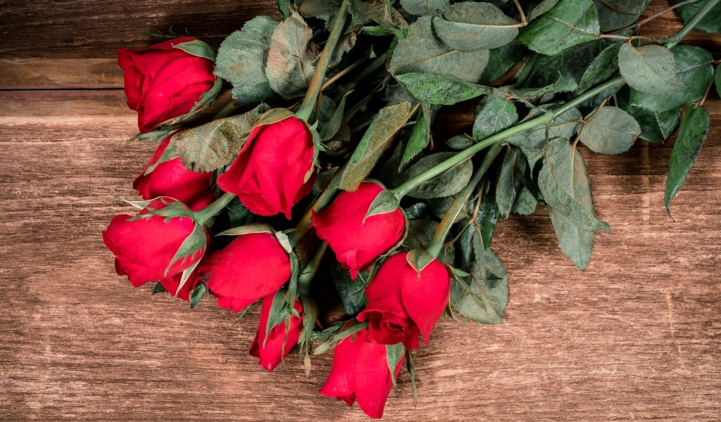 Букет красных английских роз на деревянном столе
