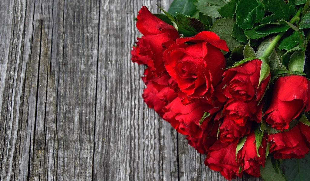 Букет красных роз на деревянном столе