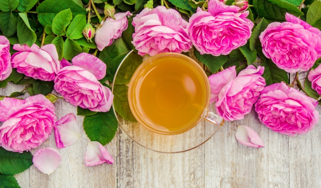 Букет роз с чашкой чая на столе