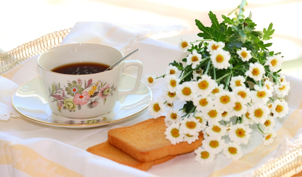 Букет белых ромашек с чашкой чая  и хлебом