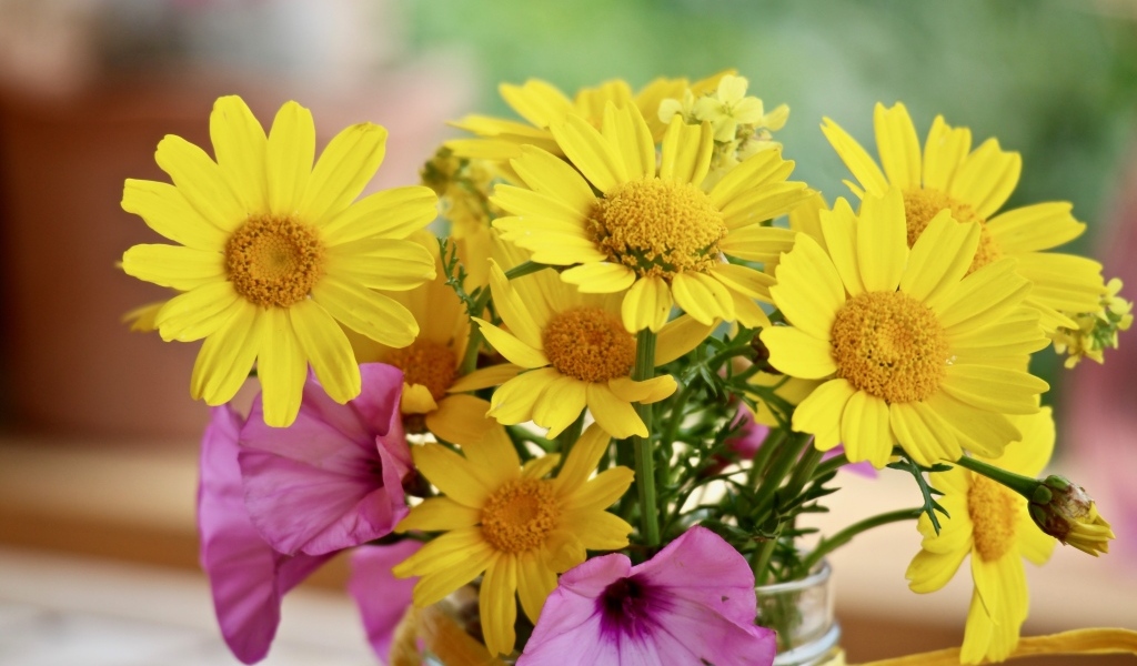 Букет желтых и розовых цветов в вазе на столе