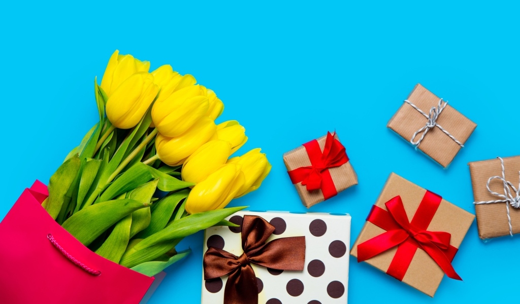 Букет желтых тюльпанов с подарками на голубом фоне