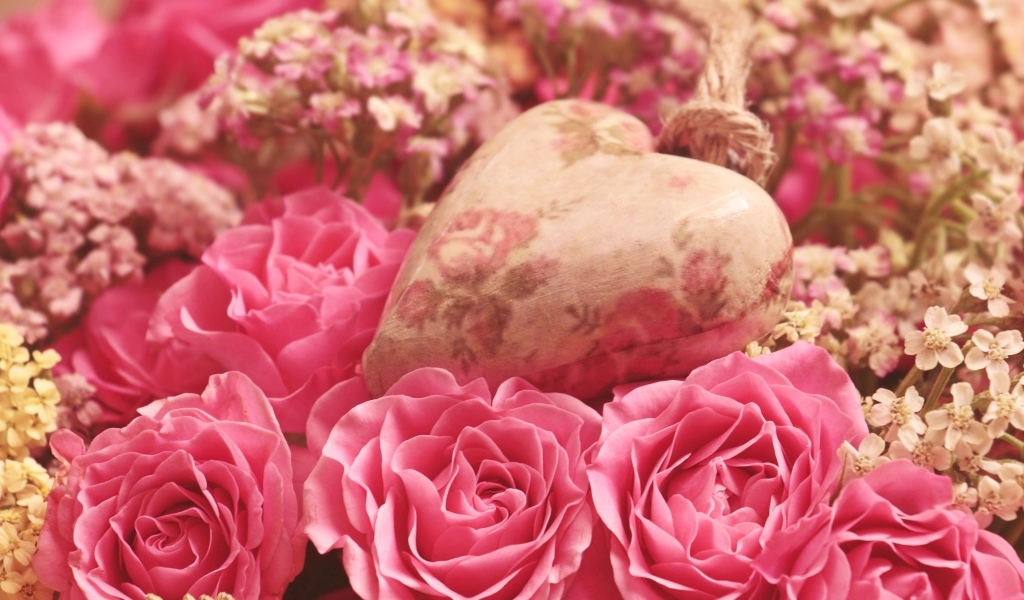 Сердце лежит на цветах розовой розы