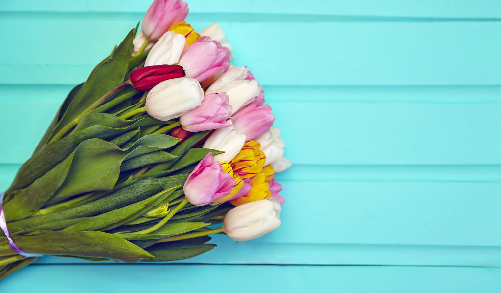 Большой букет разноцветных тюльпанов на голубом фоне