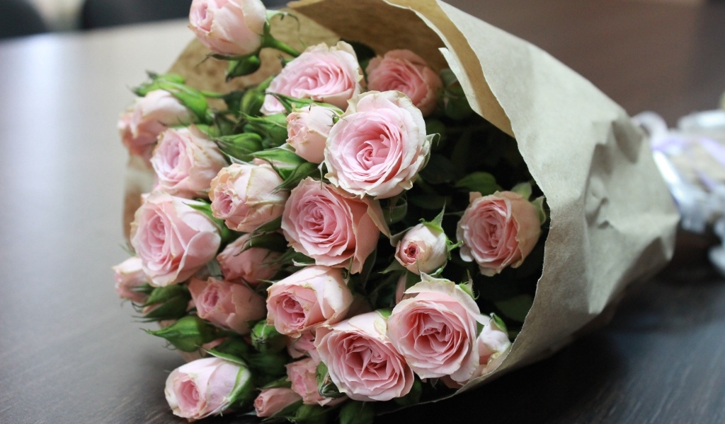 Большой букет розовых роз в бумажной упаковке