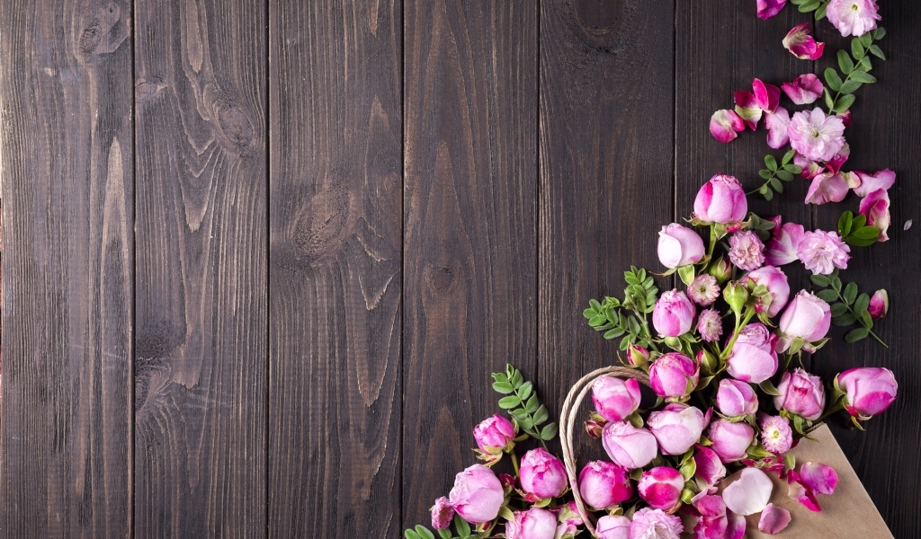 Бутоны розовой розы на деревянном столе