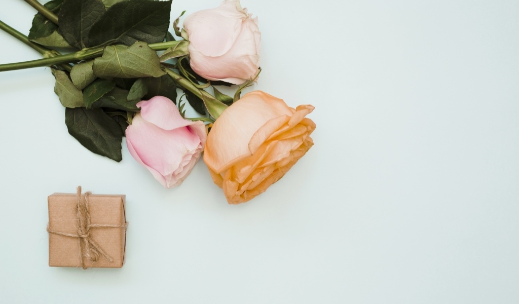 Три розы и подарок на сером фоне