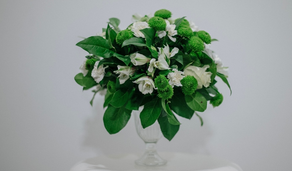 Белый букет с зелеными листьями на сером фоне