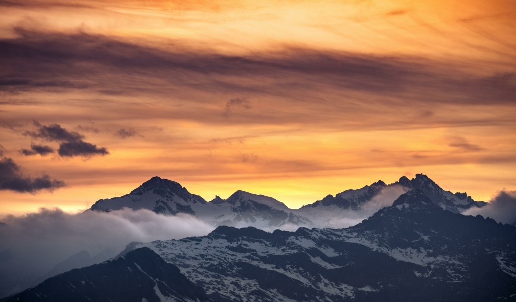 Красивый закат в небе над заснеженными горами