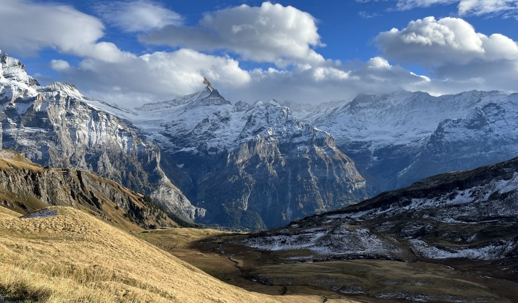 Высокие покрытые снегом горы в белых облаках
