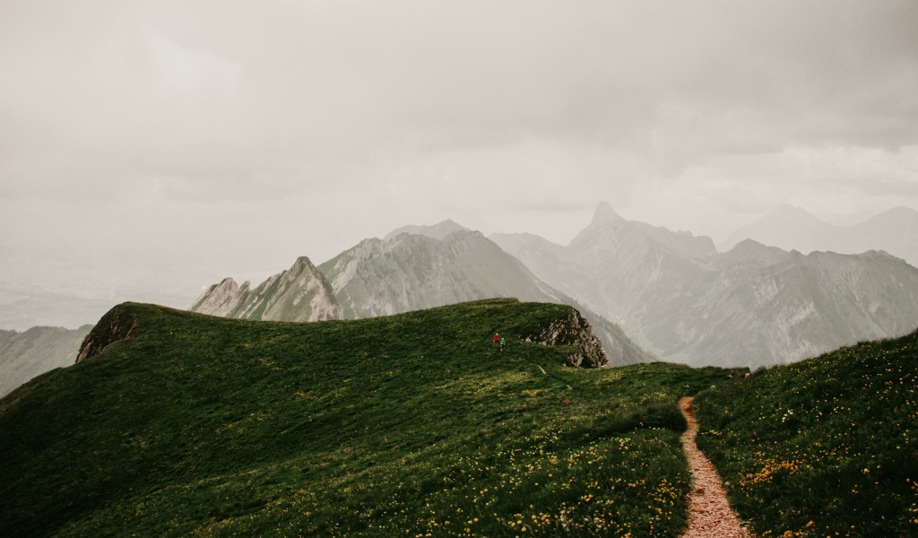 Тропа в покрытых зеленой травой горах