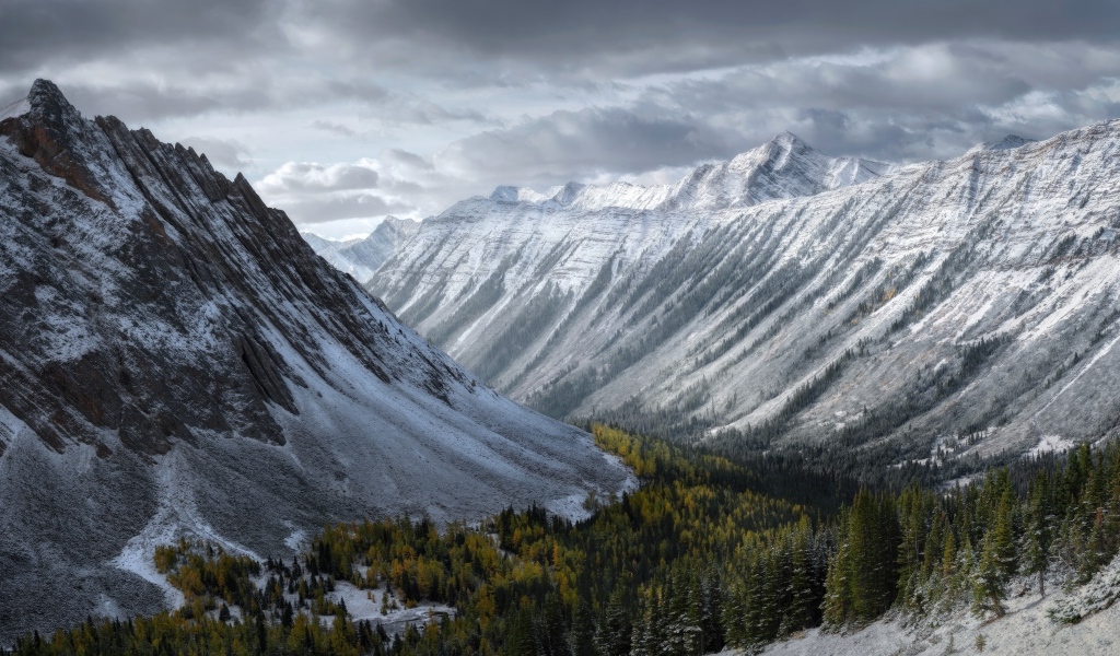 Покрытые снегом горы под грозовым небом