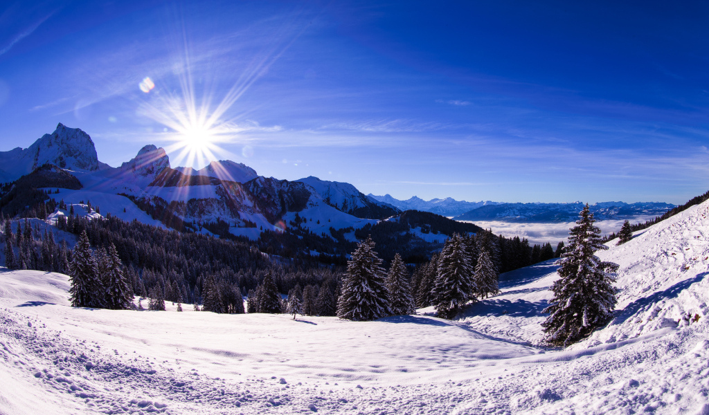 Яркое солнце освещает заснеженные альпы