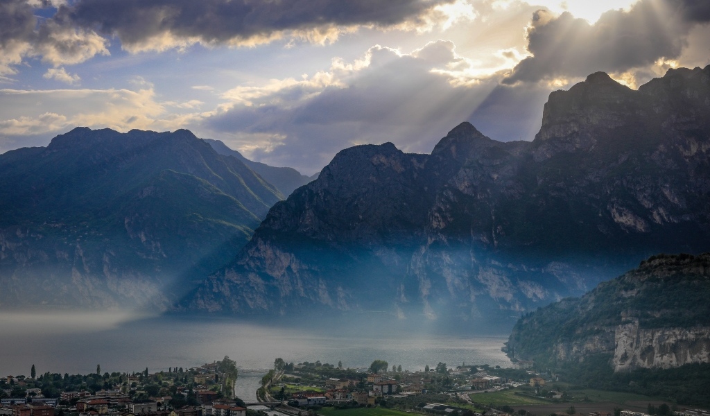 Лучи солнца покрывают горы и город 