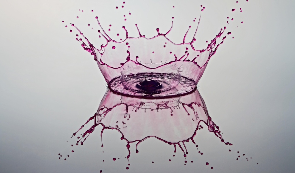 Красные брызги воды на сером фоне