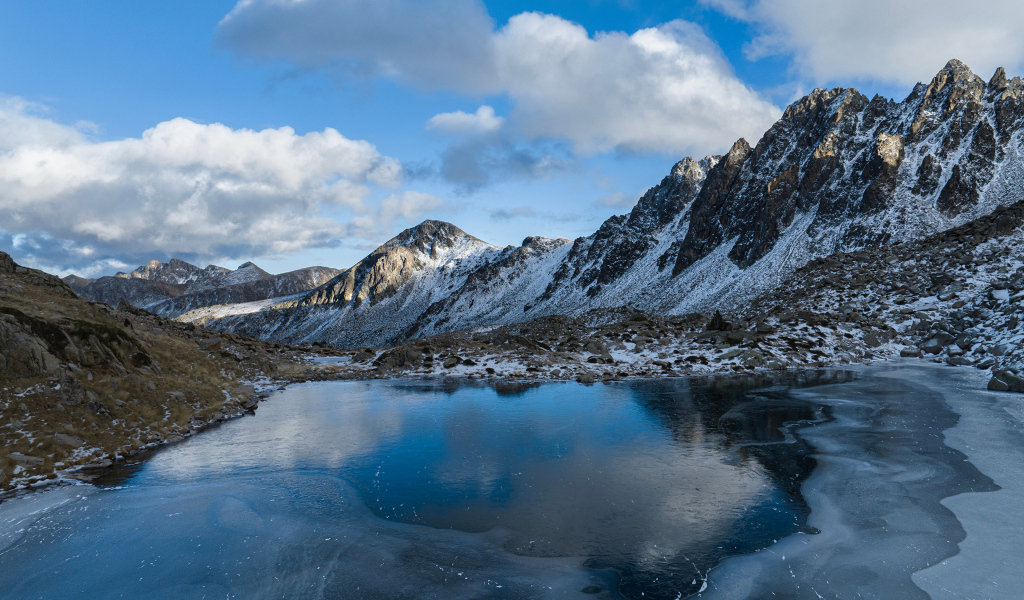 Холодный мороз покрывает льдом воду горного озера