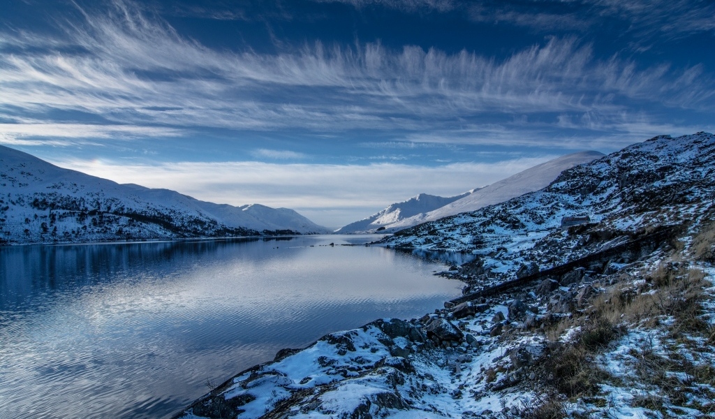 Озеро с покрытыми снегом горами под красивым небом