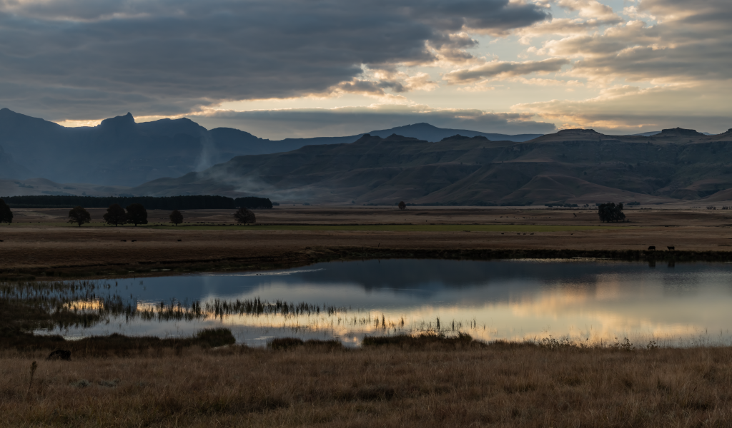 Грозовые облака отражаются в воде озера в горах 