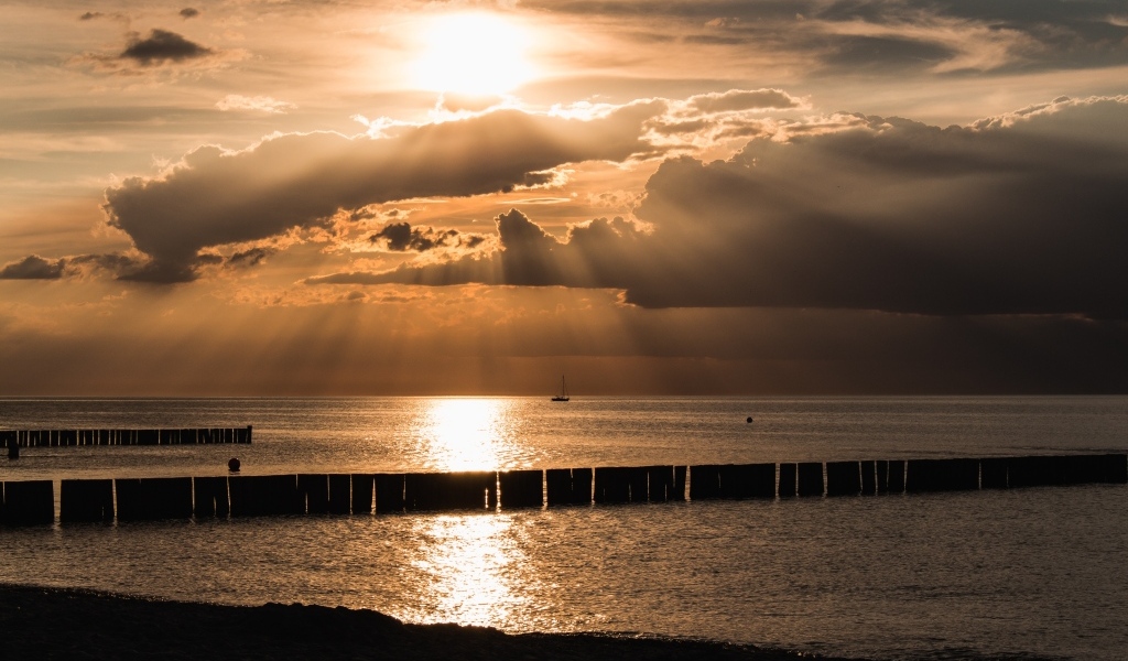 Яркое солнце за облаками над морем