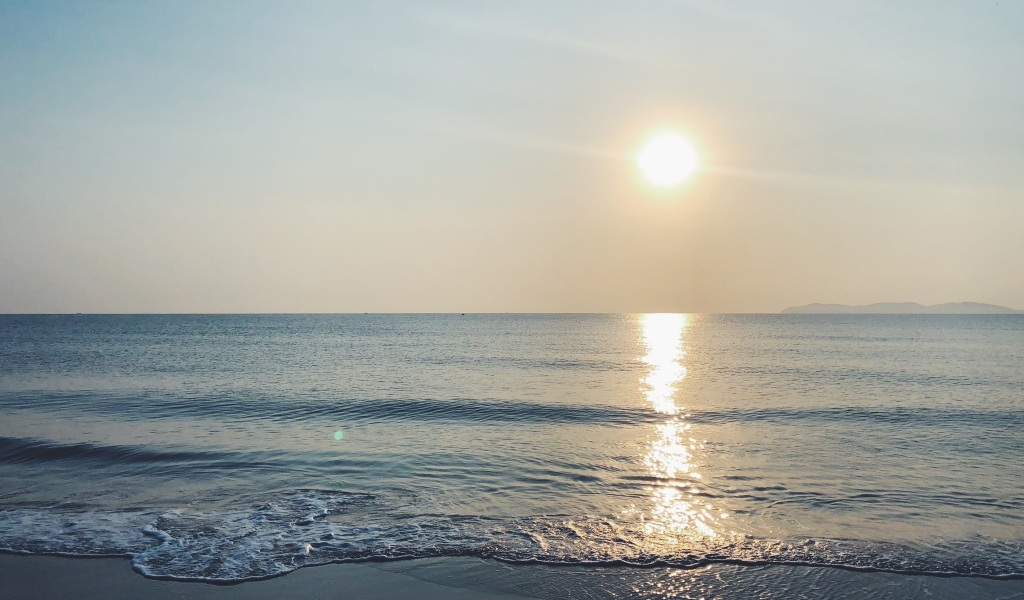 Яркое солнце над спокойным морем летом