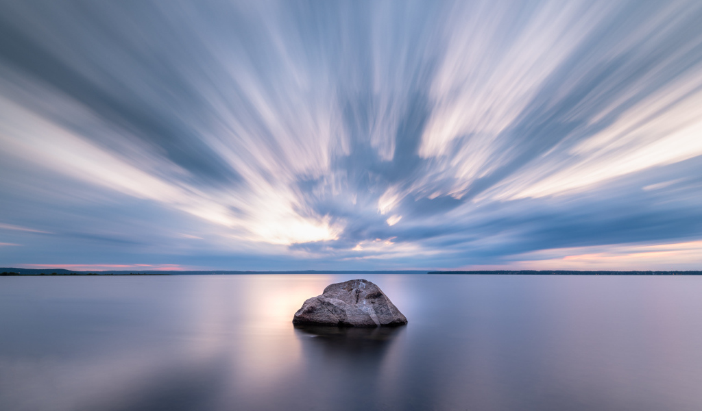 Большой камень в воде под красивым небом