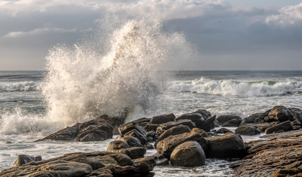 Морские волны бьются о камни на берегу