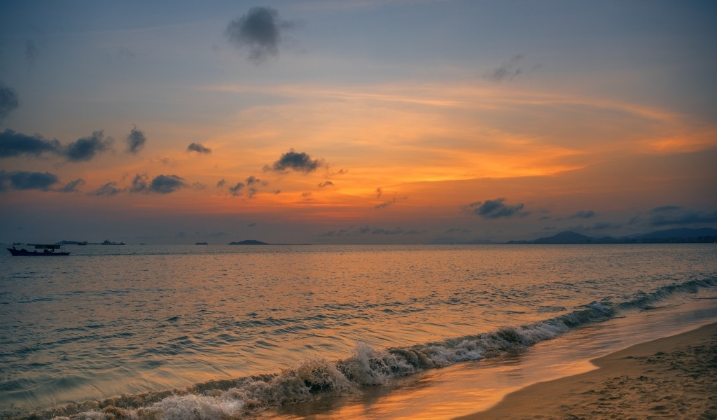 Морские волны омывают берег на закате