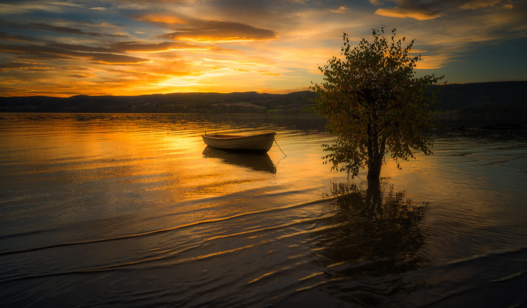 Лодка в воде спокойного озера на закате солнца