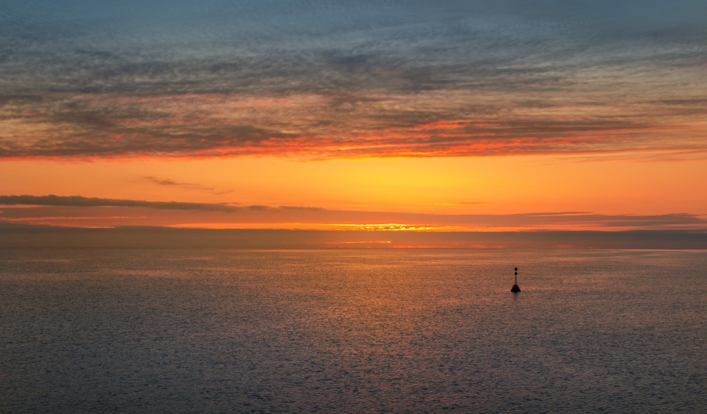 Яркий оранжевый закат на морском горизонте