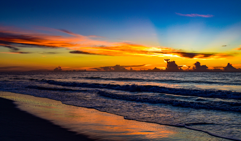 Яркие лучи солнца на закате над морем