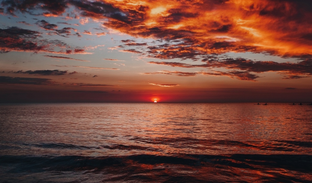 Красные облака в небе над морем на закате