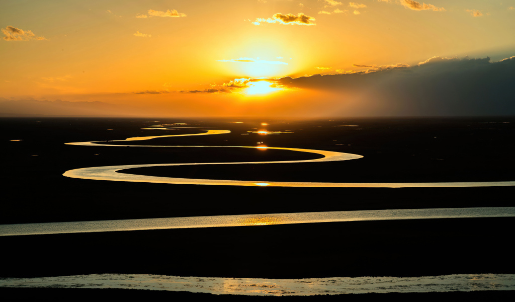 Извилистая река в лучах солнца на закате