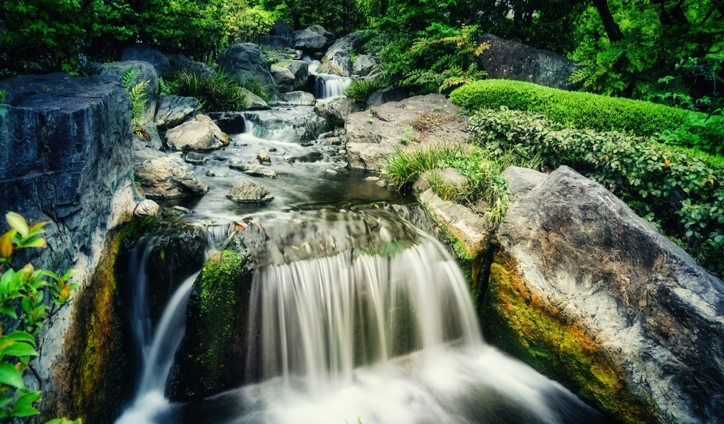Водопад стекает по камням лесной горной реки