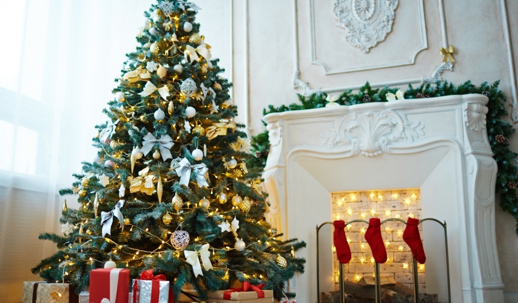Красивая наряженная ель в комнате с камином