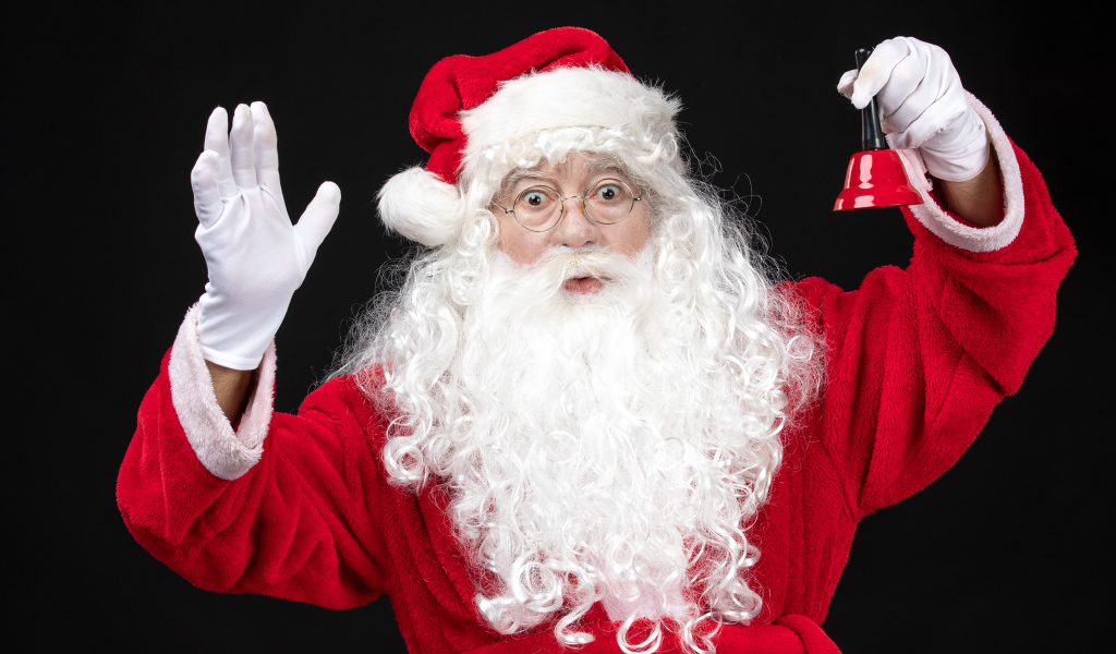 Удивленный Санта Клаус с колокольчиком в руках
