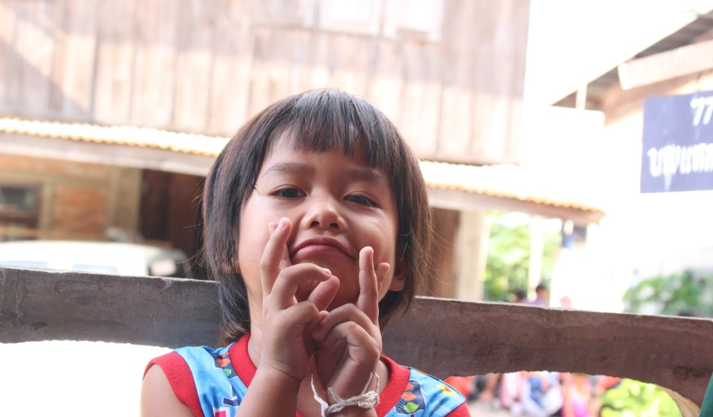 Девочка азиатка с руками  у лица