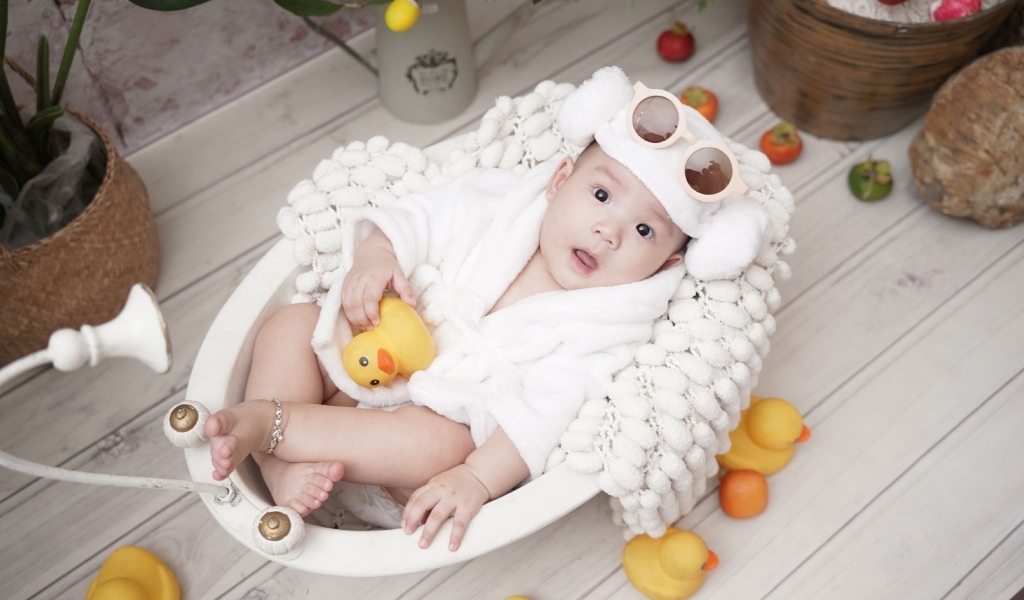 Ребенок в белой игрушечной ванной