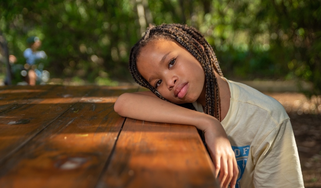 Красивая темнокожая девочка с косичками на голове 